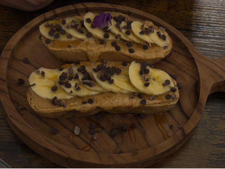 Carta de Cafeterías en Reus, HERBIVORE PLANT BASED & FERMENTED FOOD, Torrada plátano, mantequilla de cacahuete, sirope de arce, gotas de chocolate y virutas de cacao