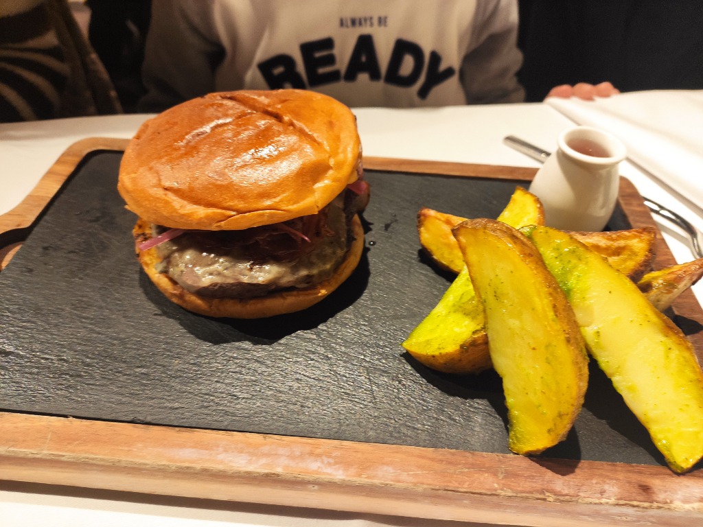 Carta de Restaurantes en Mieres del Camín, La Mendiga, Hamburguesa "La Mendiga". (Carne de vaca vieja, queso, bacón, cebolla, lechuga y tomate)