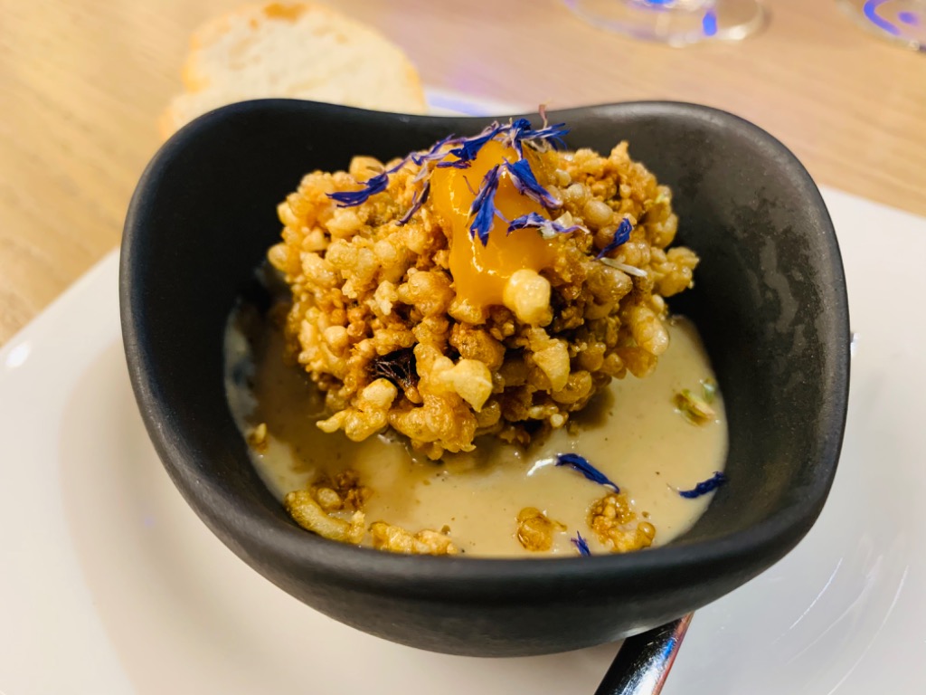 Carta de Bares en Pamplona, Bar Monasterio, Rabo de toro desmigado envuelto en airbag de patata con foie y mango, en base de salsa de boletus