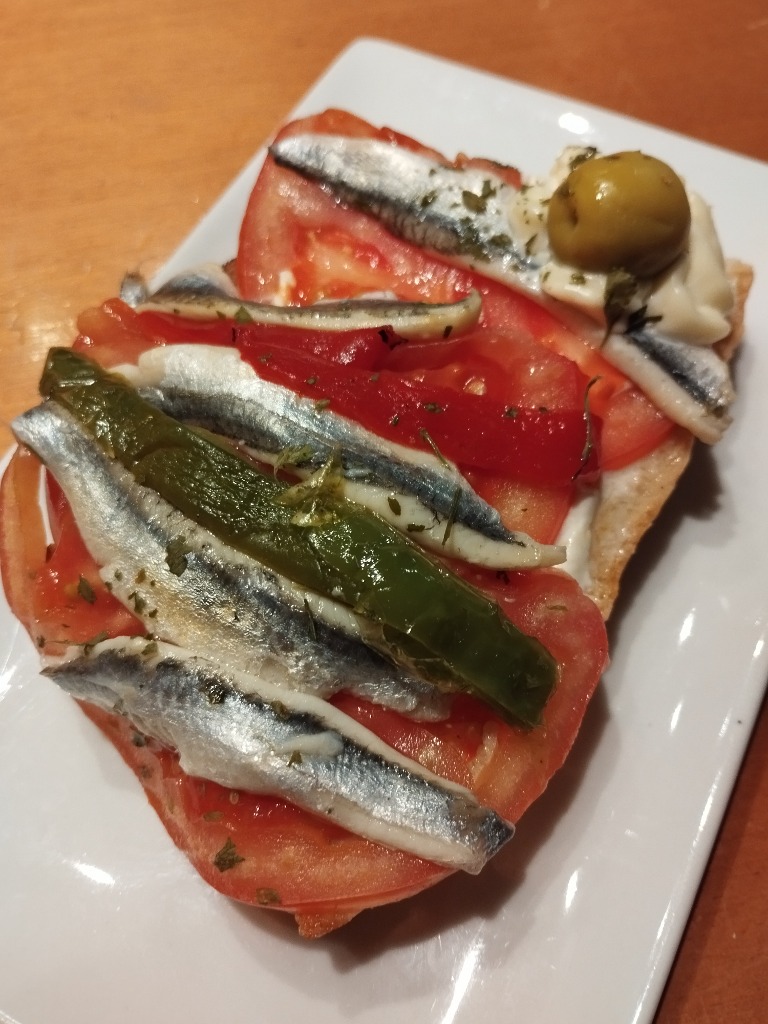 Carta de Restaurantes en Pamplona, El Alivio Bar, Tostada con boquerones, tomate, pimiento, alioli y aceituna