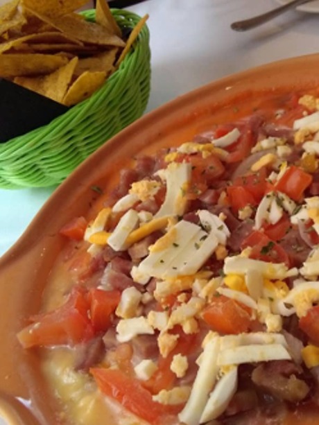 Carta de Restaurantes en Pamplona, Tabla Tomasa Cocina Internacional, Nachos Puebla: cazuela de queso fundido, pico de gallo picante, beicon, huevo, cebolleta, orégano y totopos de maiz