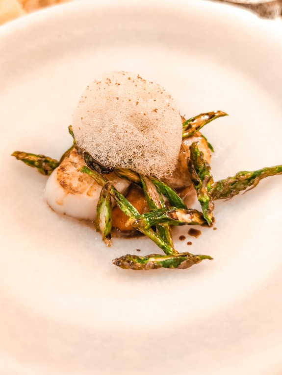 Menu of Restaurants in Seville, Az-Zait Restaurante, Vierias a la brasa con esparragos trigueros y espuma de regaliz sobre salsa romesco