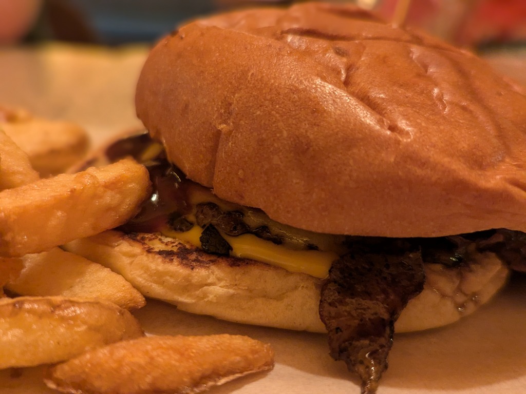 Carta de Restaurantes en Valencia, Cocolinda Alameda, Doble cheese burger pan brioche, doble smash burger 100% vacuno, beicon crujiente, cebolla, queso cheddar, salsa barbacoa y salsa casera de queso. Acompañada de patatas fritas caseras