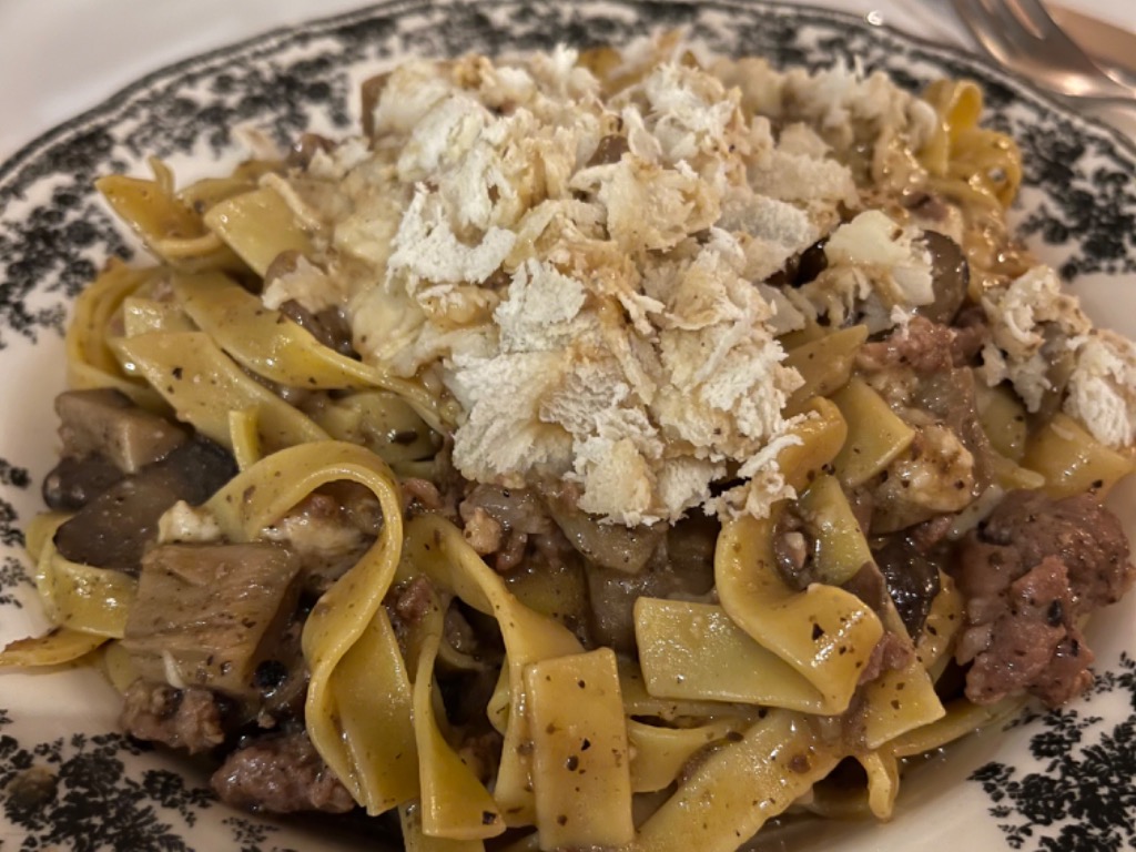 Carta de Restaurantes en Valencia, LatteeFarinaValencia, Tagliatelle porcini con boletus, crema de trufa, y longaniza italiana mezclada en la mesa en rueda de queso parmesano
